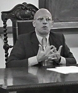michel foucault sat at a desk