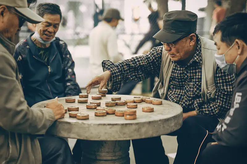 four men playing a board game socialising