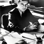 Black and white image of Erving Goffman sat at his desk