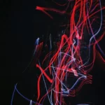 An abstract lined image in red and white on black background