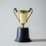 A gold trophy on a black stand meritocracy