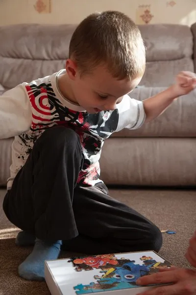 A young boy demonstrating ability by doing a jigsaw puzzle