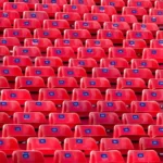 Lines and columns of identical red chairs.