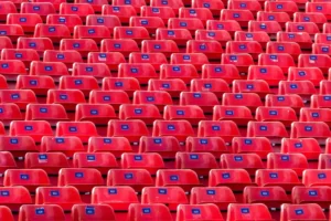 Lines and columns of identical red chairs.