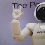 A white robot doing devil horns - automation