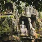 A stone carving of the Buddha in a large rock