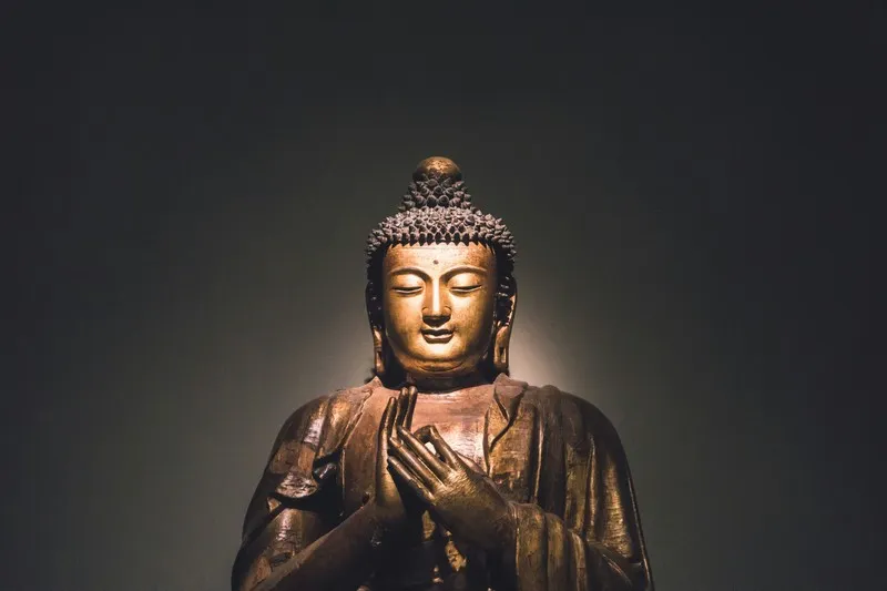 The Buddha with a spotlight on his face and a dark background