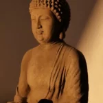 A statue of the buddha in shades of brown