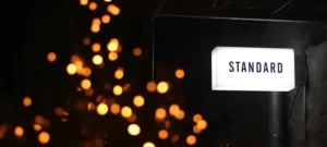 night shot of a light box sign saying 'standards'