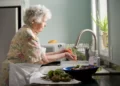 A woman doing housework - peeling vegetables at the sink