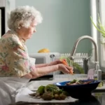 A woman doing housework - peeling vegetables at the sink