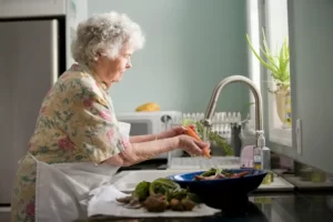 A woman doing housework - peeling vegetables at the sink
