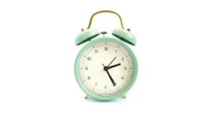 green alarm clock against a white background