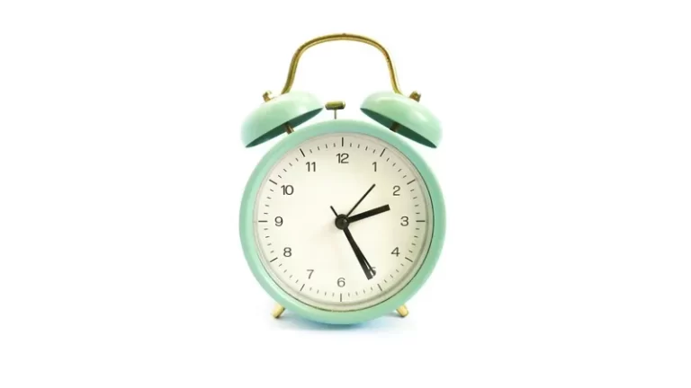 green alarm clock against a white background