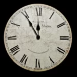 A white clock against a black background. It has roman numerals and displays the time as 11:55