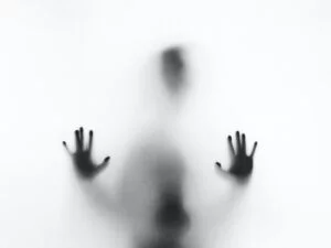 A figure behind a white screen