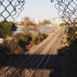 A hole on a fence on the railway - crime and deviance
