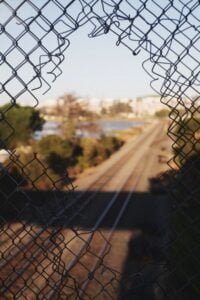 A hole on a fence on the railway - crime and deviance