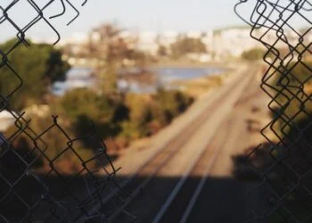 A hole on a fence on the railway - crime and deviance