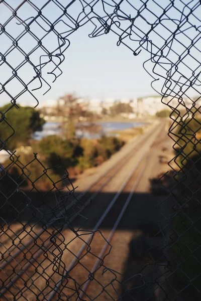 A hole on a fence on the railway - crime and deviance