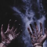 A pair of hands covered in industrial dirt