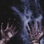 A pair of hands covered in industrial dirt