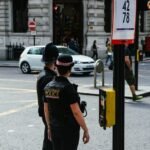 two police waiting to cross the road