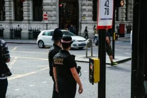 two police waiting to cross the road