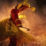 A fire-enveloped person wearing cultural dress and performing a cultural dance