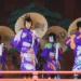 4 japanese people at a festival wearing kimonos and holding traditional sun umbrellas