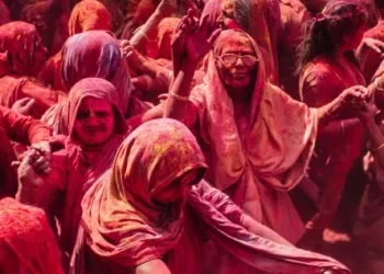 Women covered in red paint at a cultural festival