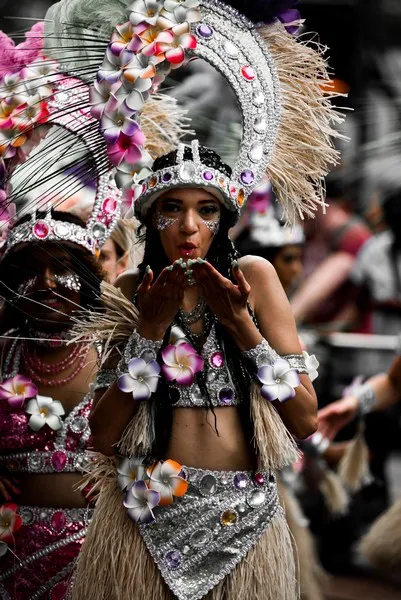 A woman in cultural dress blowing a kiss