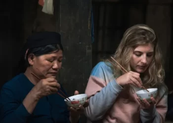 Two women of differing ethnicities sharing a bowl of cultural food