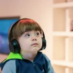 A disabled child wearing headphones looking thoughtful