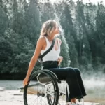 A disabled woman tavelling in a national park with trees in the background