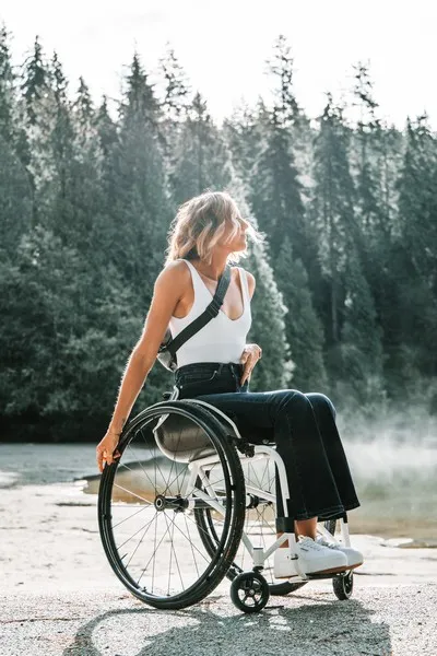 A disabled woman tavelling in a national park with trees in the background