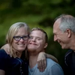 A young man with downs syndrome and his parental carers