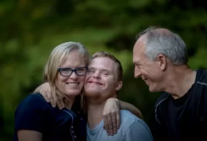 A young man with downs syndrome and his parental carers