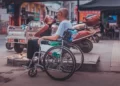 A disable man sat in a wheelcahir facing out into the road