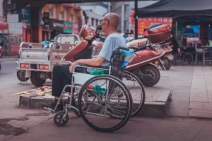 A disable man sat in a wheelcahir facing out into the road
