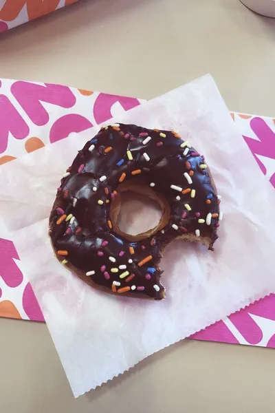 a chocolate donut with a bite taken out