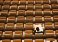 A single student sat in a lecture hall - neoliberal effect on education