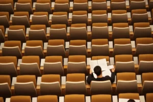 A single student sat in a lecture hall - neoliberal effect on education