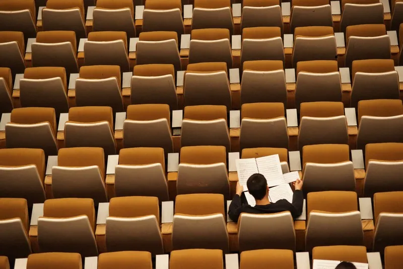 A single student sat in a lecture hall - neoliberal effect on education