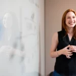 A teacher teaching in front of a whiteboard.