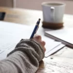 A person writing an exam in the exam driven nature of schooling