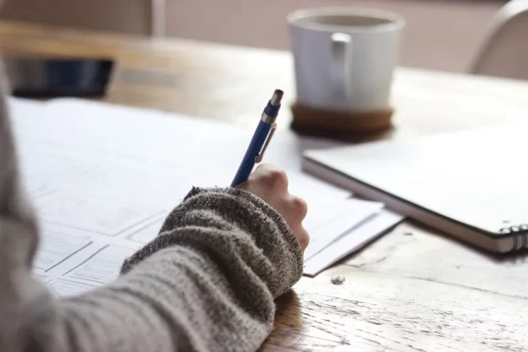 A person writing an exam in the exam driven nature of schooling