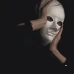 a man performing a role in a white mask