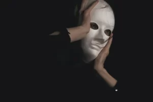 a man performing a role in a white mask