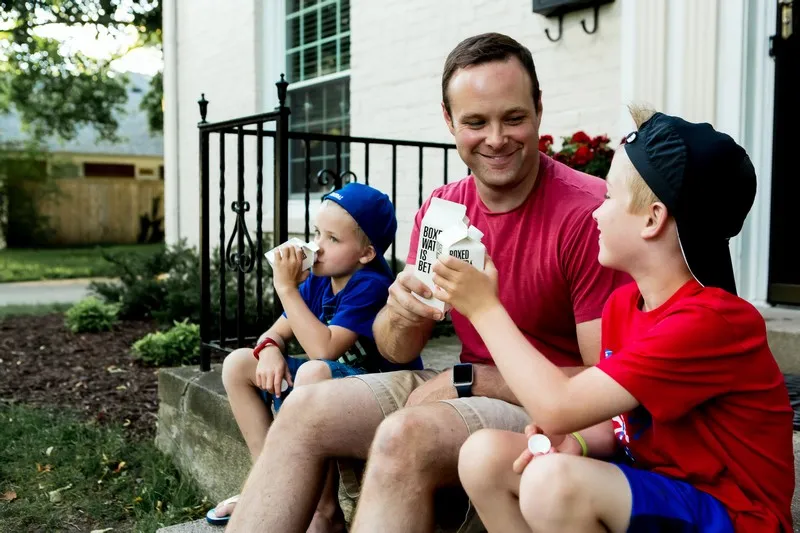 A father and two sons all having a pint of milk each